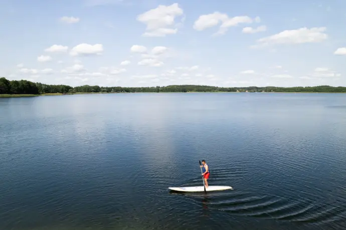 Pływanie na SUP z wiosłami po jeziorze